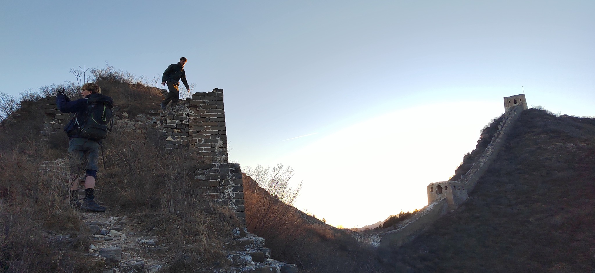 Hikers exploring the unrestored Great Wall and its mountain watchtowers