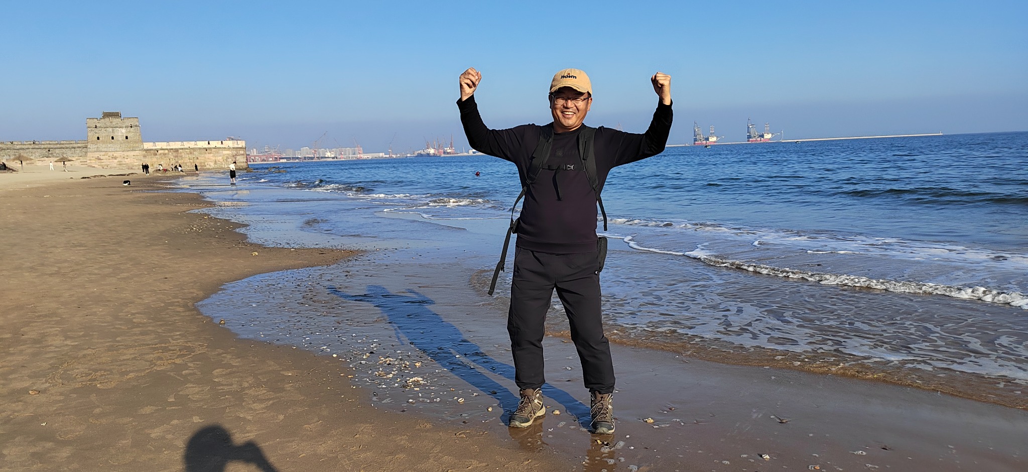 Traveler celebrating beside the Great Wall at the coast